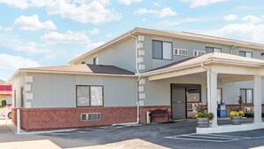 A two-story motel with a covered parking area and a bench outside. - Super 8 by Wyndham Poplar Bluff Missouri (Poplar Bluff)