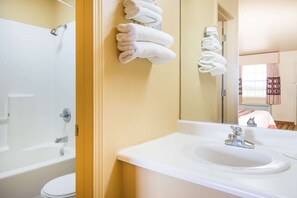 A bathroom with a bathtub, toilet, and sink.
