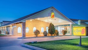 A Super 8 motel with a covered front entrance, brick facade, and a well-lit parking area.