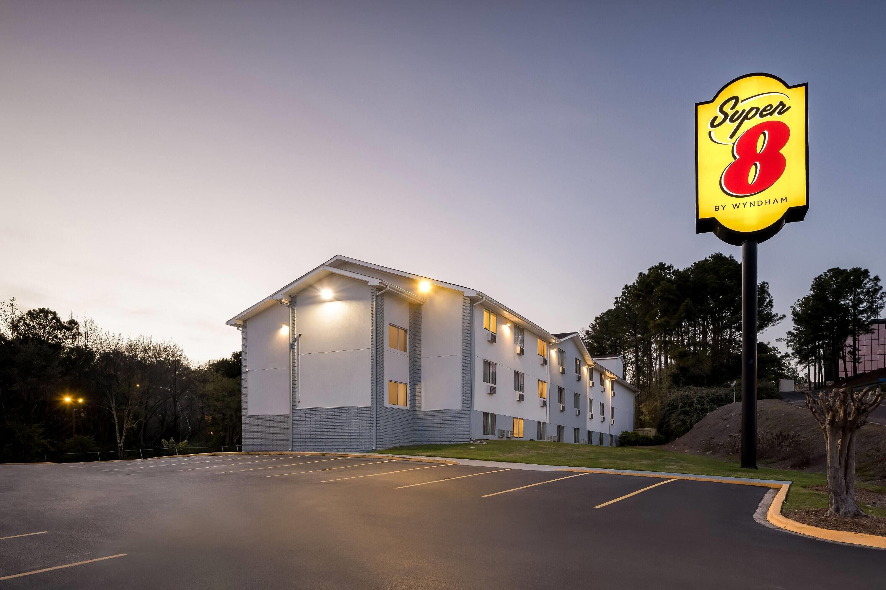 Un hotel Super 8 con un edificio moderno, un estacionamiento y un cartel.