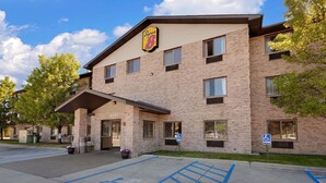 A multi-story brick building with a Super 8 sign, indicating it is a Super 8 motel. There are handicap parking spaces and a covered entrance. - Super 8 by Wyndham Mt. Pleasant (Mount Pleasant)