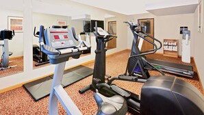 A hotel gym with cardio machines, a treadmill, and a mirrored wall. - Super 8 by Wyndham Mt. Pleasant (Mount Pleasant)