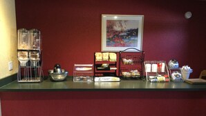 A breakfast bar with coffee makers, a bowl, and various food items. - Super 8 by Wyndham Mt. Pleasant (Mount Pleasant)