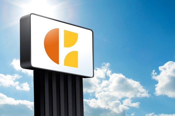 A sign with a stylized logo against a clear blue sky with clouds. - Orlando Inn International Drive Area (Orlando)