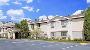 A multi-story hotel with a parking lot in front. - Super 8 by Wyndham Cloquet (Cloquet)