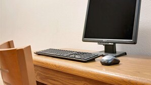 A wooden desk with a black keyboard, a mouse, and an Acer monitor. - Super 8 by Wyndham Cloquet (Cloquet)
