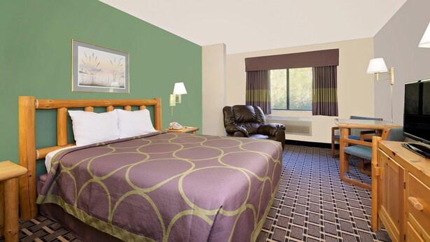 A hotel room with a bed, a desk, a chair, a television, and a window with curtains. - Super 8 by Wyndham Cloquet (Cloquet)