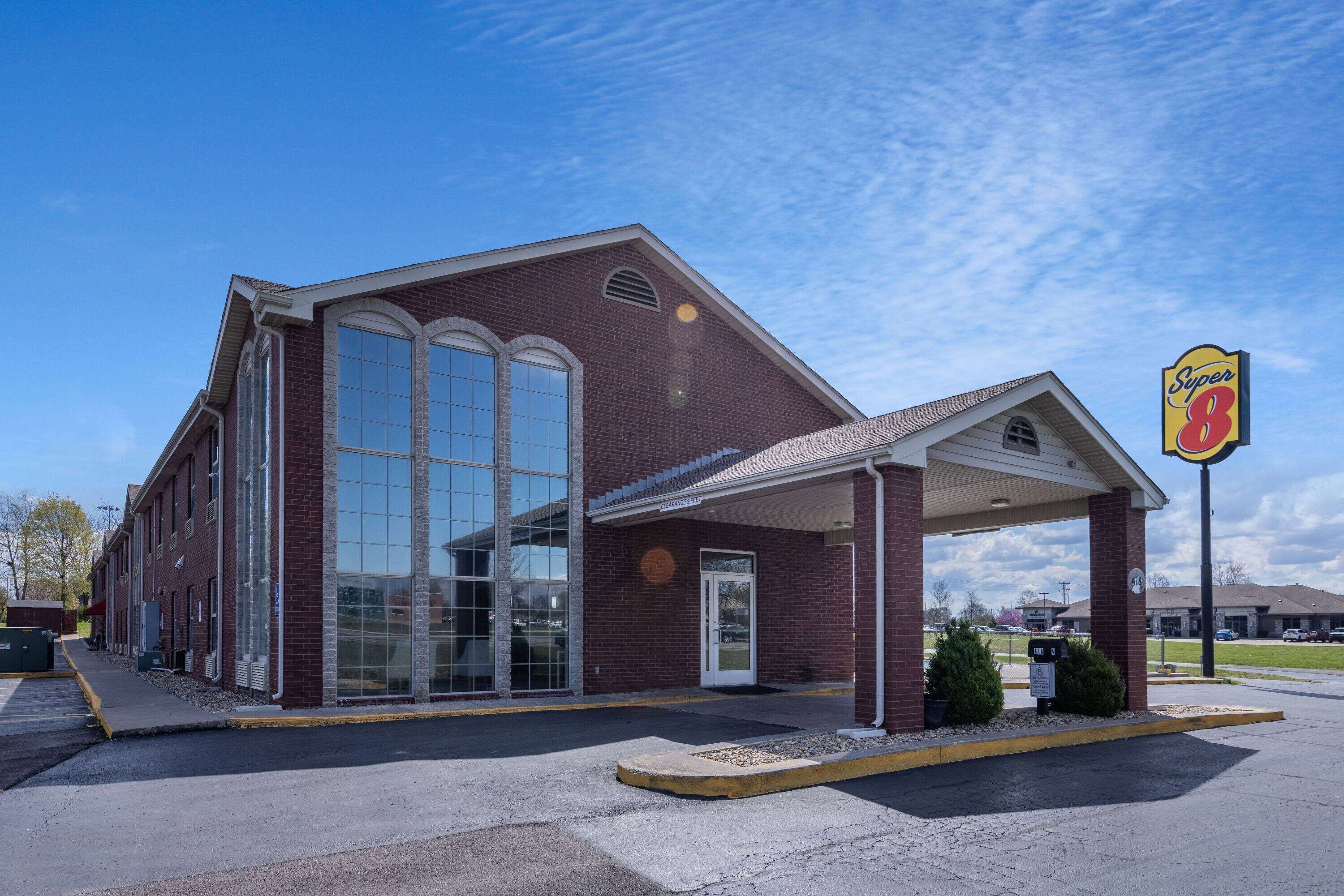 A Super 8 motel with a brick facade, large windows, and a covered parking area.