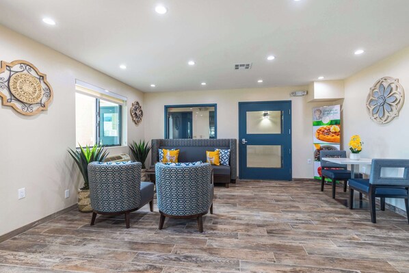 A spacious indoor area with a seating arrangement, a door, and decorative wall art.