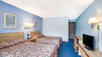 Une chambre d’hôtel avec deux lits, une télévision et un bureau avec une chaise.