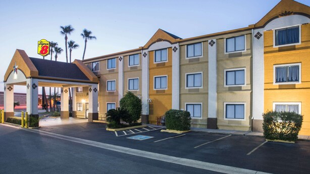 A hotel with a Super 8 sign, multiple floors, and a parking lot.