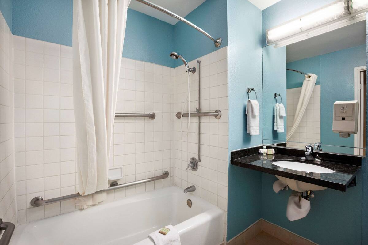 A bathroom with a bathtub, shower, and sink.