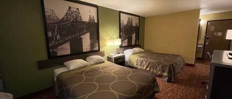 Habitación de hotel con dos camas, una mesita de noche, una lámpara y un cuadro grande en la pared.