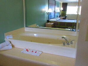 Une salle de bain d’hôtel avec une grande baignoire, un lavabo et un miroir.