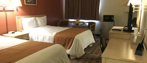 Une chambre d’hôtel avec deux lits, un bureau, une chaise, une télévision et une petite table.