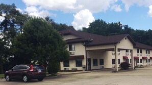 Un motel composé d’un bâtiment principal et d’un espace de stationnement couvert.