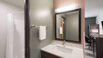 A bathroom with a sink, mirror, towel rack, and shower curtain.