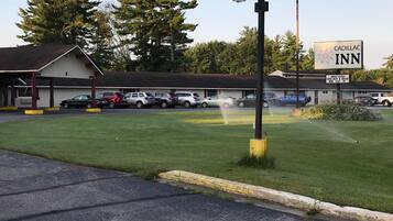 A Cadillac Inn with a parking lot, a covered waiting area, and a lawn in front.