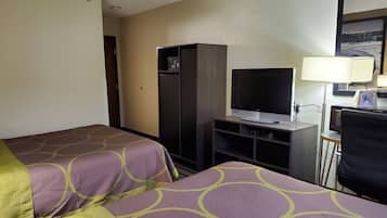 A hotel room with two beds, a TV, a desk, a chair, and a lamp.