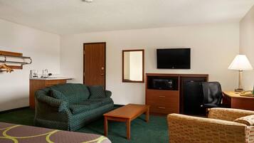 Une chambre d’hôtel équipée d’un lit, d’un canapé, d’un bureau, d’une télévision et d’un four à micro-ondes.