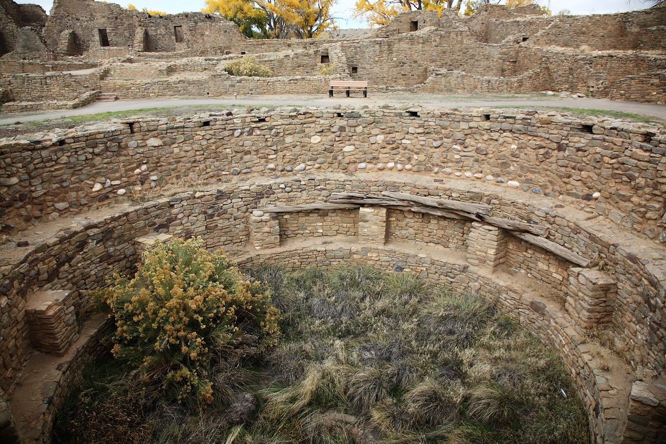 An ancient stone amphitheater with tiered seating and a central stage.