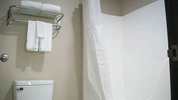 Un bagno con un water, un portasciugamani con asciugamani piegati e una tenda da doccia.