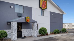 Un hôtel Super 8 au design moderne, avec une façade en pierre et une vue dégagée sur le ciel.