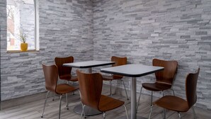 Un intérieur moderne avec des murs en pierre grise, des chaises et des tables en bois.