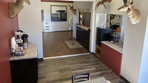Un hall d’hôtel avec un plancher en bois, un comptoir de réception et des têtes d’animaux fixées aux murs.