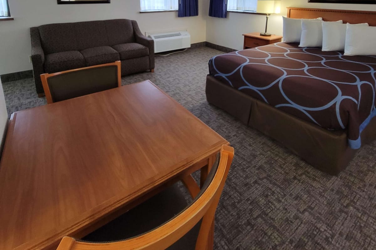 Een hotelkamer met een bed, een bank, een tafel en een stoel.