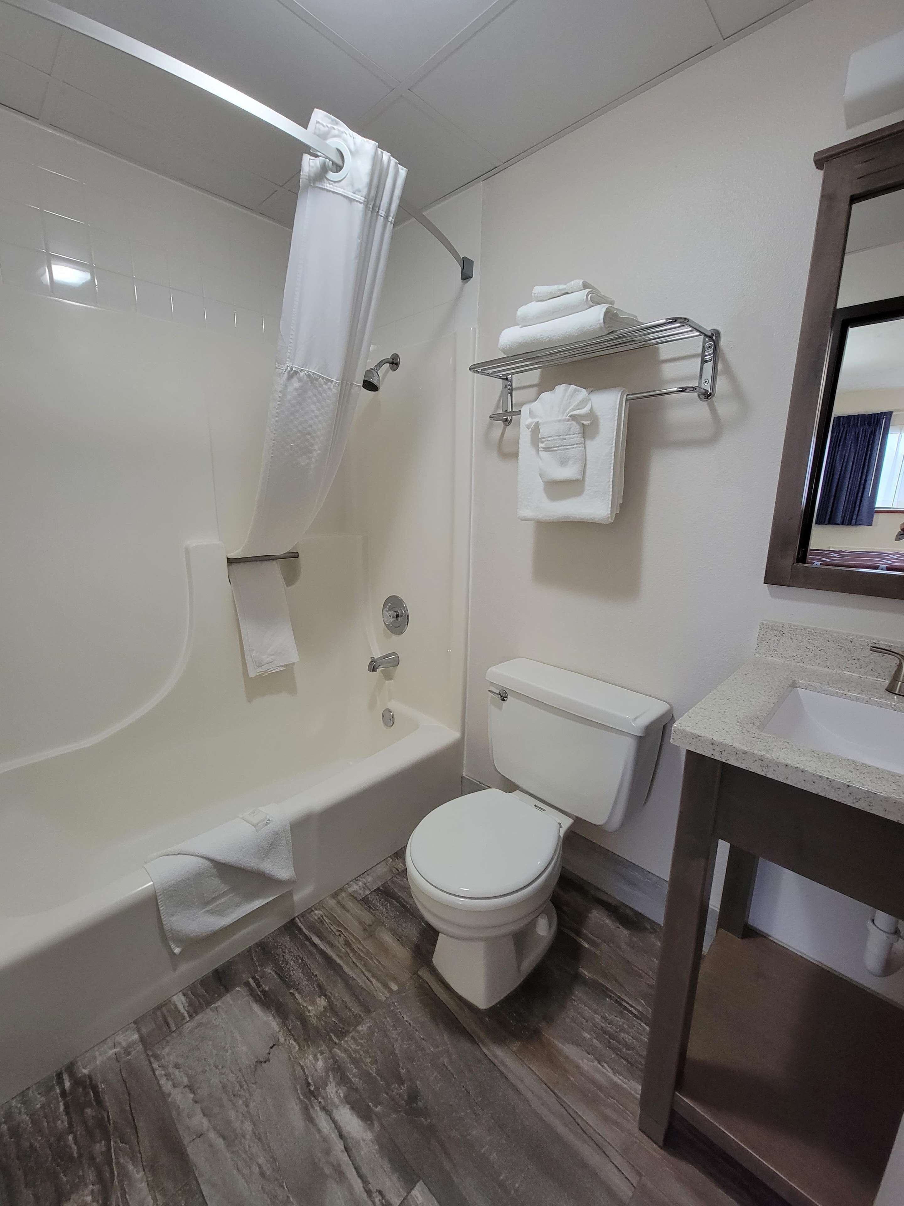 A bathroom with a bathtub, toilet, and sink.