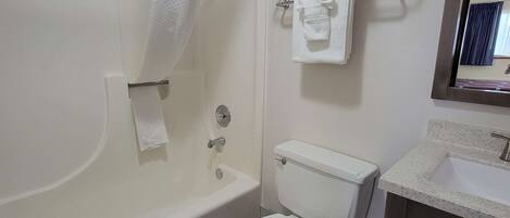 A bathroom with a bathtub, toilet, and sink.