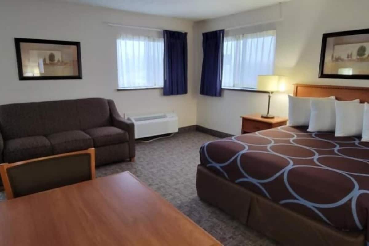 Een hotelkamer met een bed, een bank, een tafel en een bureau.