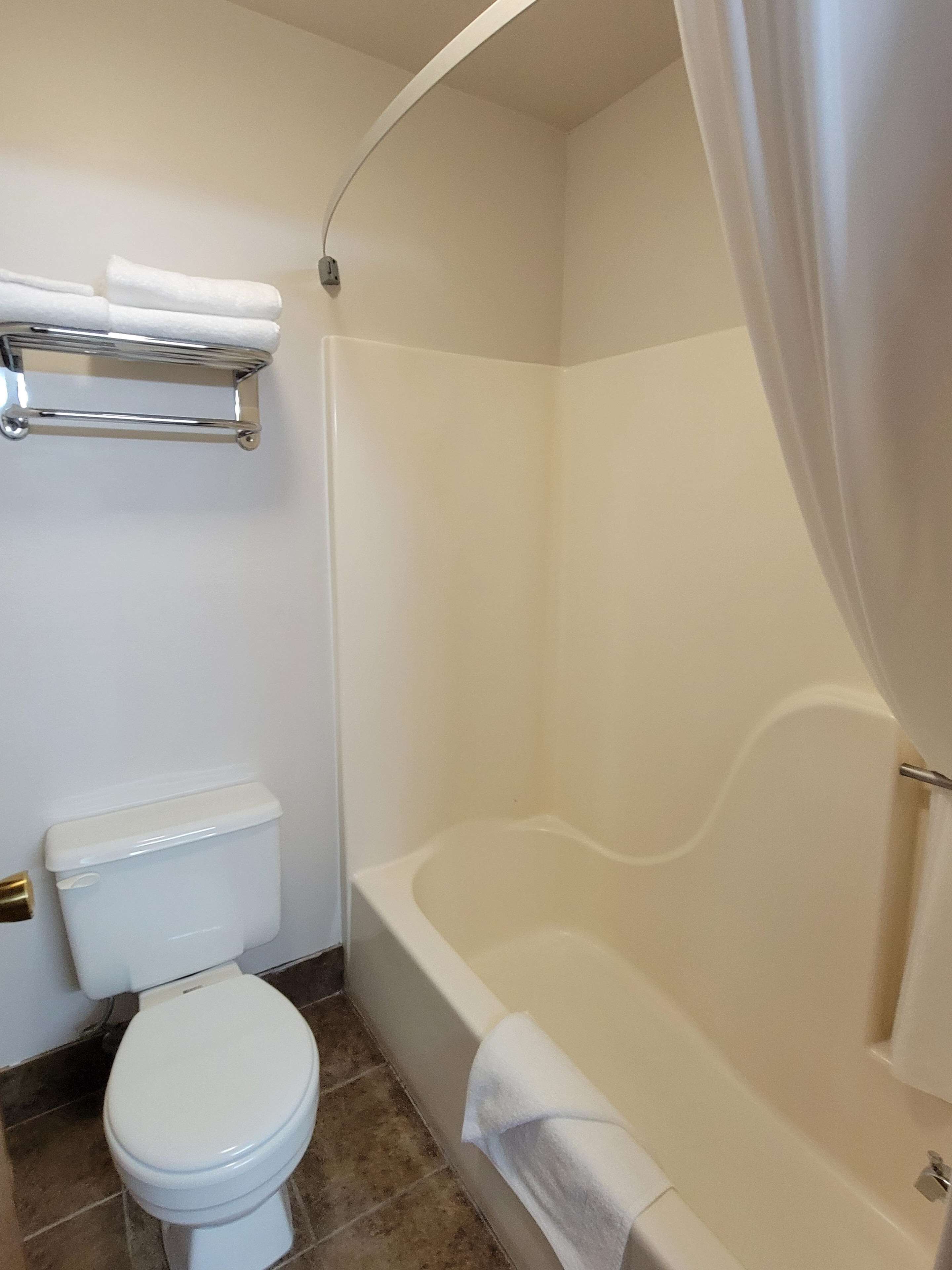 Un baño con inodoro, bañera y cortina de ducha.