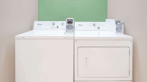 Two white Whirlpool washing machines side by side against a light green wall. - Super 8 by Wyndham Beaver Dam (Beaver Dam)