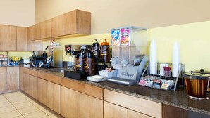 A kitchen with a coffee machine, coffee makers, and a kettle. - Super 8 by Wyndham Carroll (Carroll)