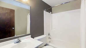A bathroom with a white sink, toilet, and bathtub. - Super 8 by Wyndham Carroll (Carroll)