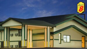A Super 8 motel with a large parking lot, multiple garages, and a prominent 'Super 8' sign. - Super 8 by Wyndham Carroll (Carroll)