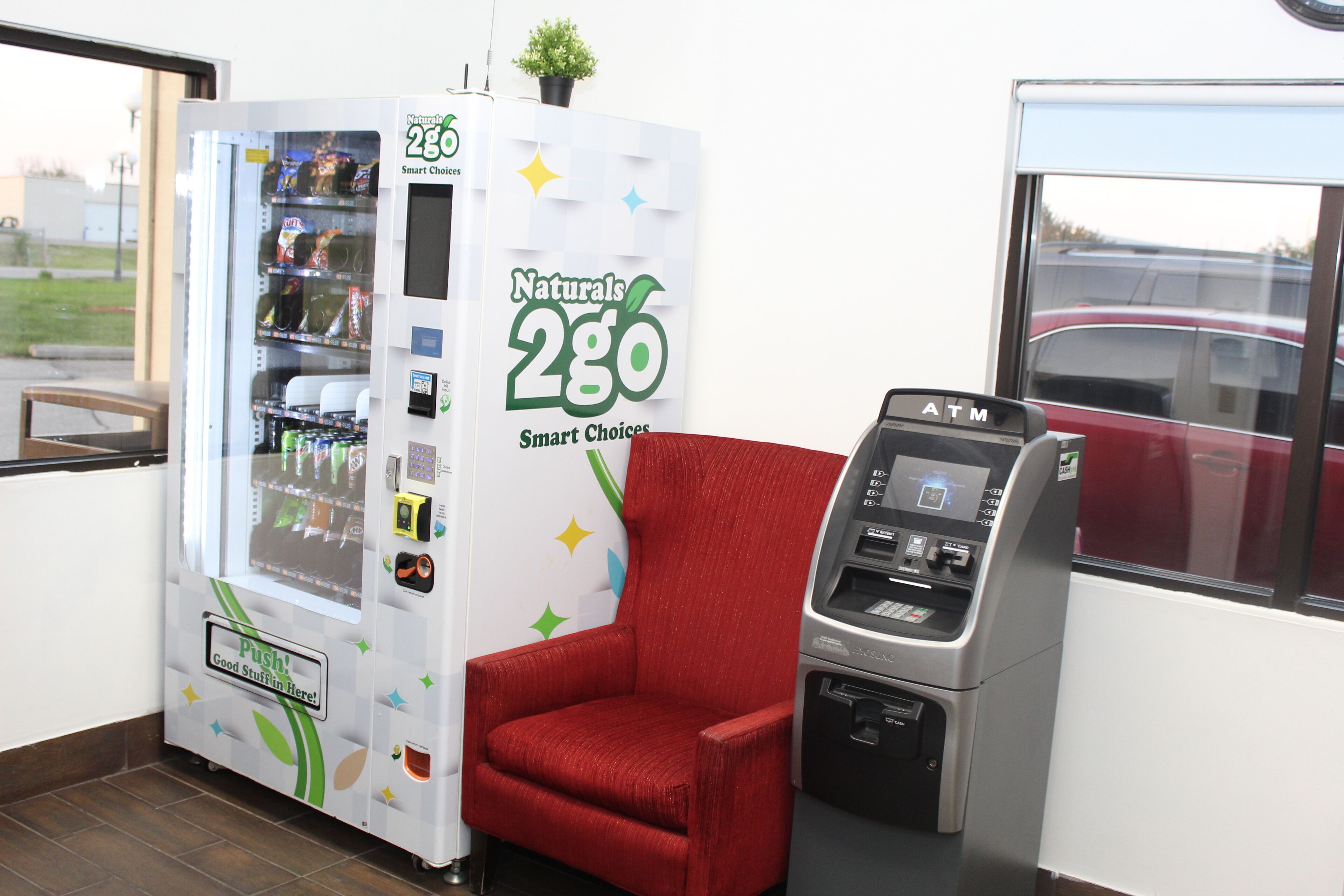 Un distributeur automatique avec une chaise à côté.