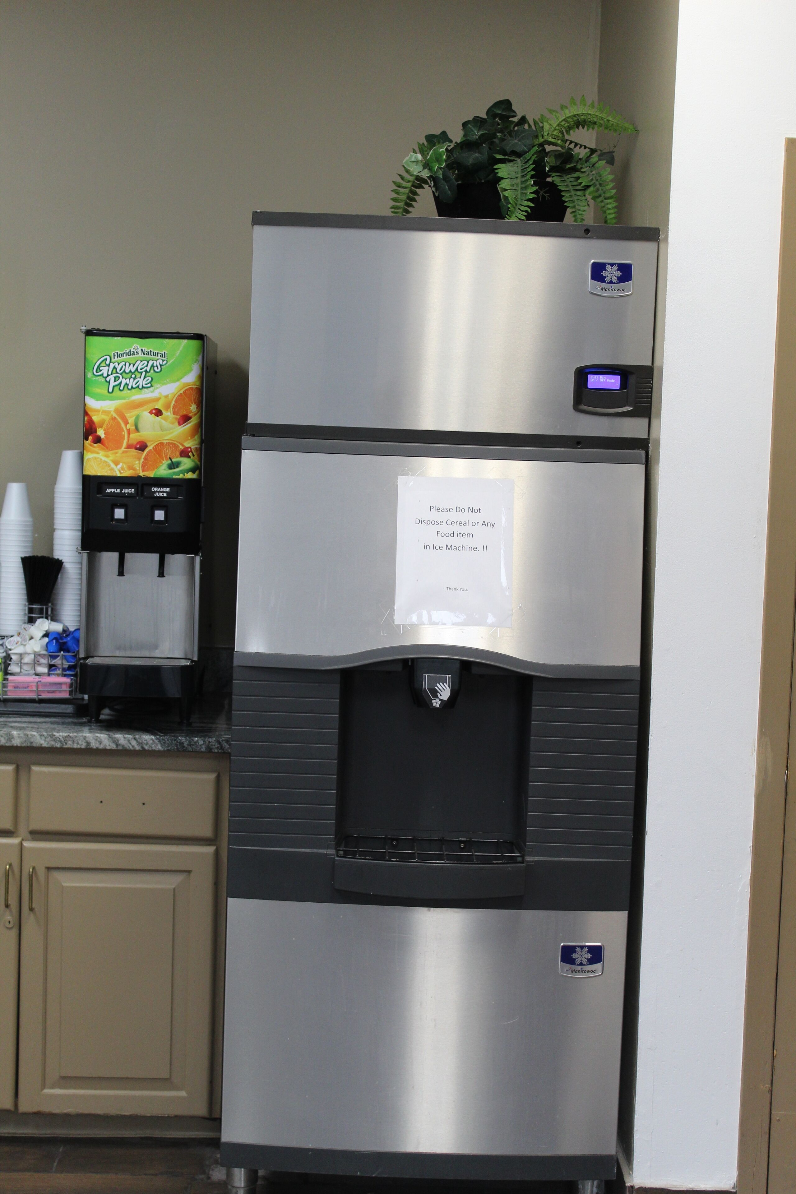 A stainless steel refrigerator with a water dispenser and a note advising against disposing of food in the ice maker.