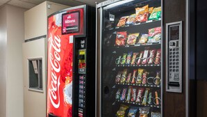 A vending machine with a Coca-Cola logo and a snack vending machine next to it.