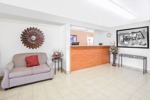 Welcome to our reception area, featuring a reception desk, a circular wall decoration, and a comfortable sofa.