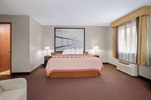 Relax in comfort with a large bed, bedside tables, and a beautiful artwork above.