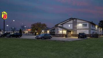 A Super 8 motel with a two-story building, parking lot, and a grassy area in front.