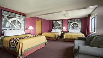 A hotel room with two beds, a sofa, and artwork on the walls.