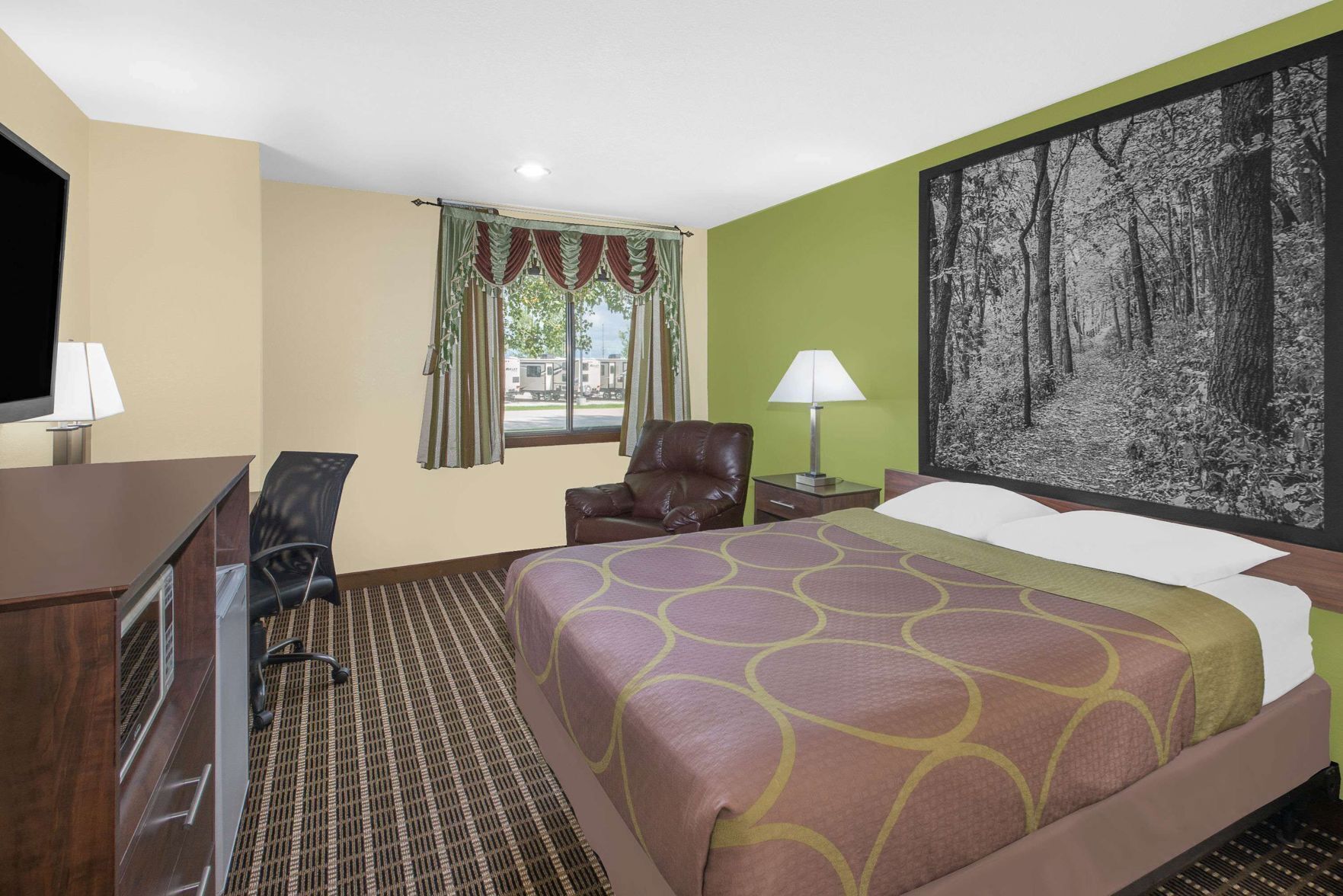 Senger med overmadrass, safe på rommet, skrivebord og blendingsgardiner