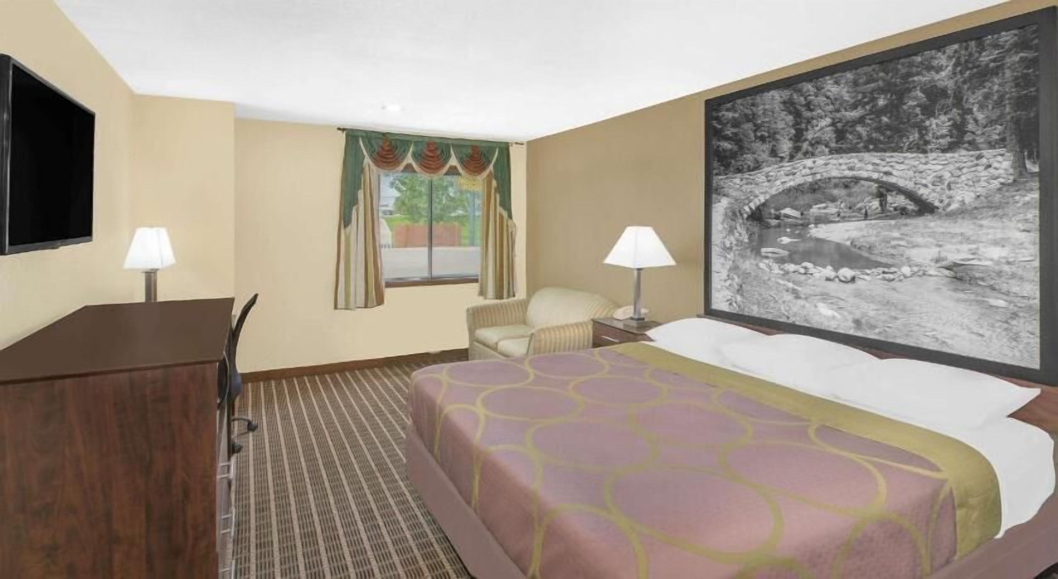 Senger med overmadrass, safe på rommet, skrivebord og blendingsgardiner