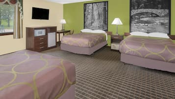 A hotel room with two beds, a desk with a computer, a TV, and artwork on the walls.