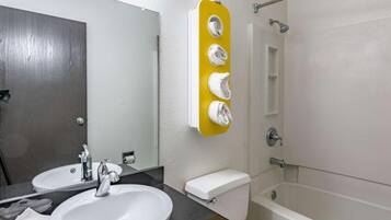 A bathroom with a sink, mirror, toilet, and shower.
