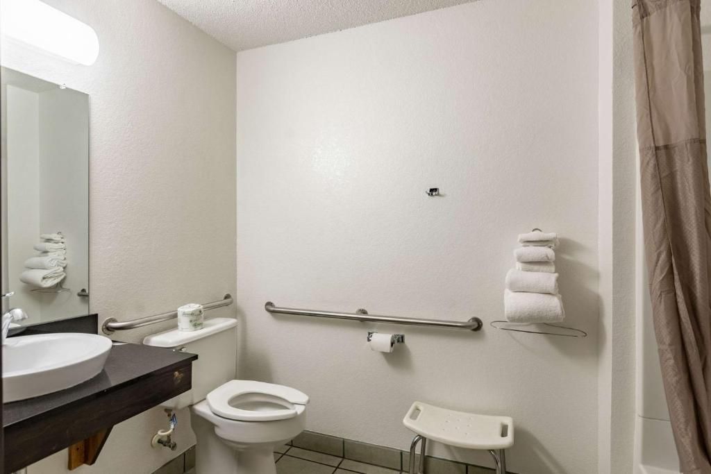 Ein typisches Hotelbad mit Waschbecken, Toilette und Dusche.